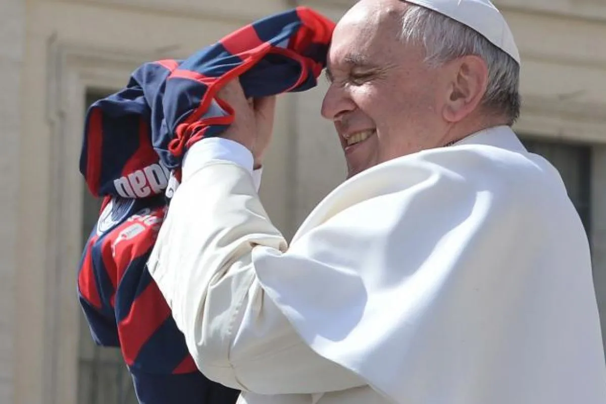 ALEGRÍA. El papa Francisco sosteniendo una camiseta de San Lorenzo lanzada por un fanático.