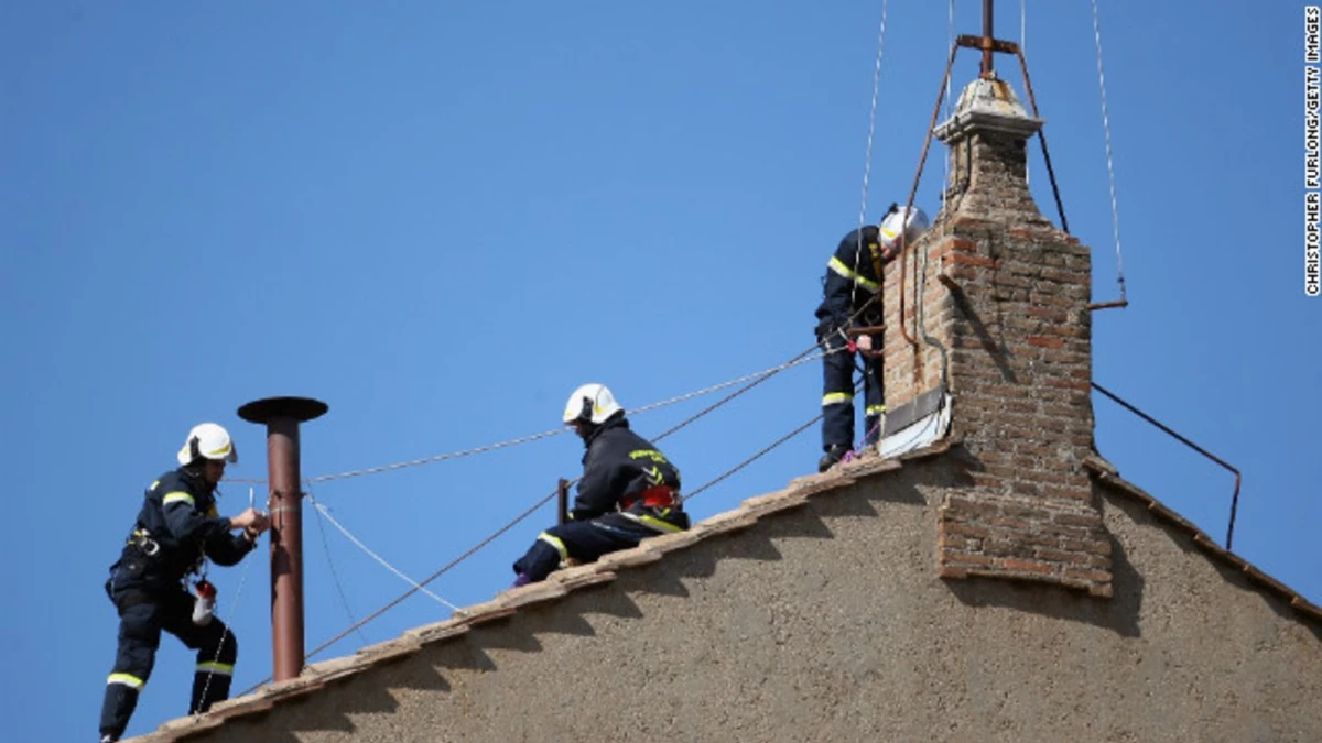 Bomberos instalan la chimenea en el techo de la Capilla Sixtina