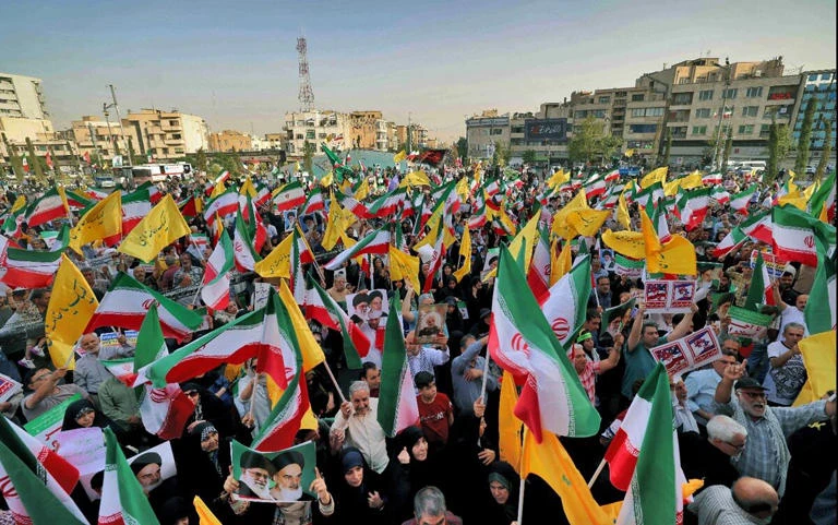 FESTEJOS. Banderas y cantos contra Israel y Estados Unidos reflejaron el alivio en Teherán por la frágil tregua.  