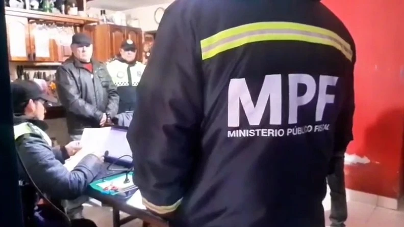 PROCEDIMIENTO. Alejandro Darío Pérez observa mientras un efectivo labra el acta de su detención.