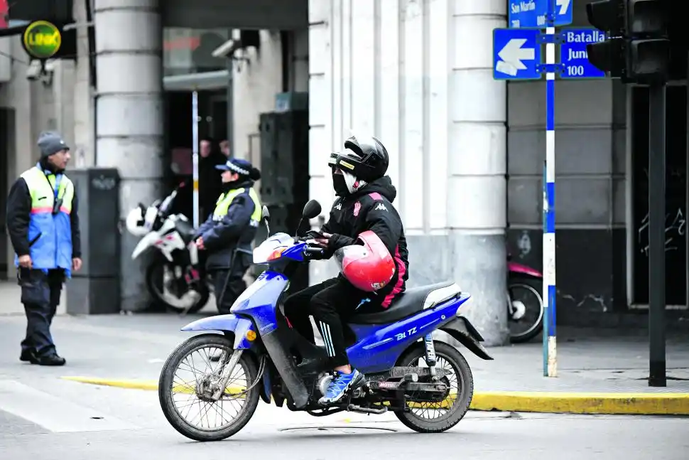 HABLANDO POR CELULAR. Pasa cerca de un policía.