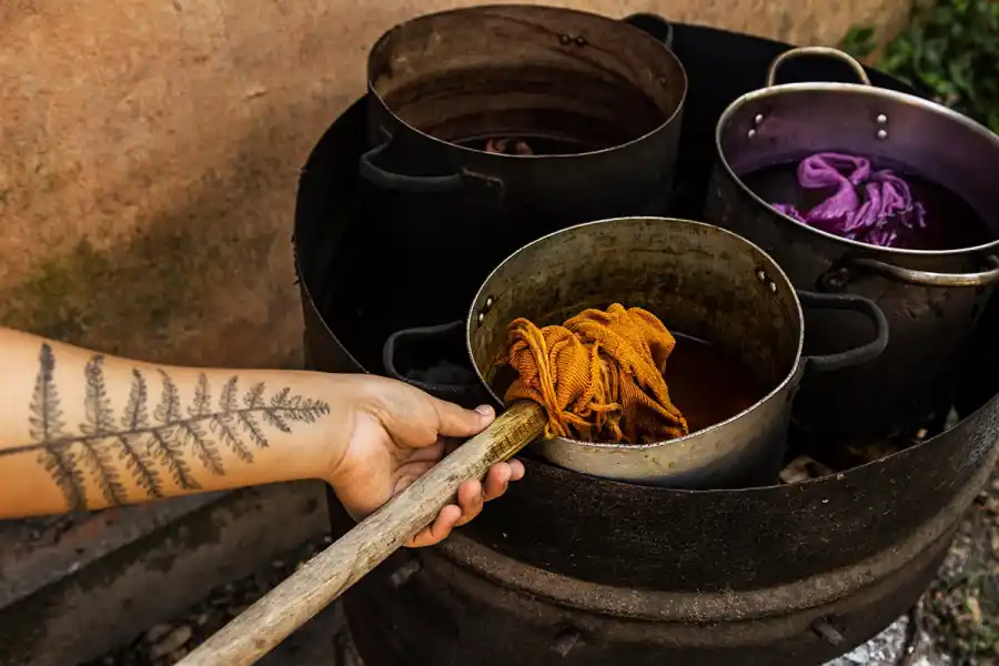 PROCESO ARTESANAL. Natalia Orozco utiliza pigmentos naturales extraídos de plantas y raíces para teñir a mano las telas de sus colecciones, manteniendo viva la tradición textil del norte argentino.