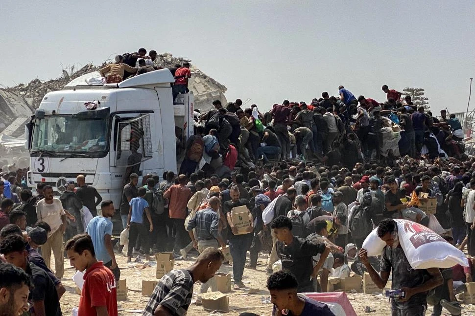 DESPLAZADOS Y HAMBRIENTOS. Refugiados palestinos saquearon un camión con ayuda alimentaria en Jan Yunis, en el sur de la Franja de Gaza. 