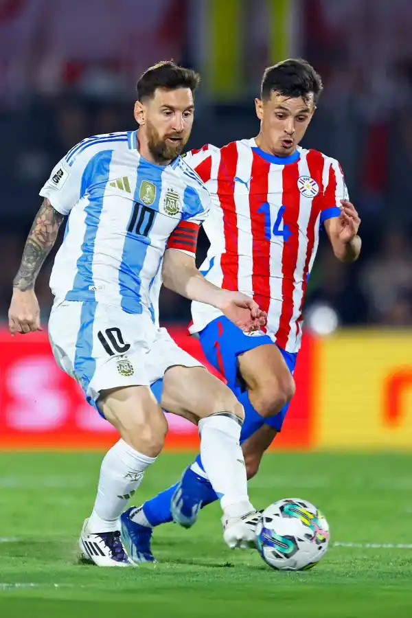 JUNTOS. Lionel Messi es marcado por Andrés Cubas, en un Argentina-Paraguay.