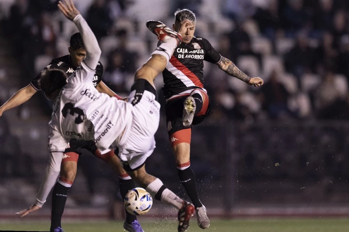 TRABADO. Franco García remata ante la marca de Alejo Rodríguez. El delantero santo fue uno de los pocos que intentó desequilibrar.