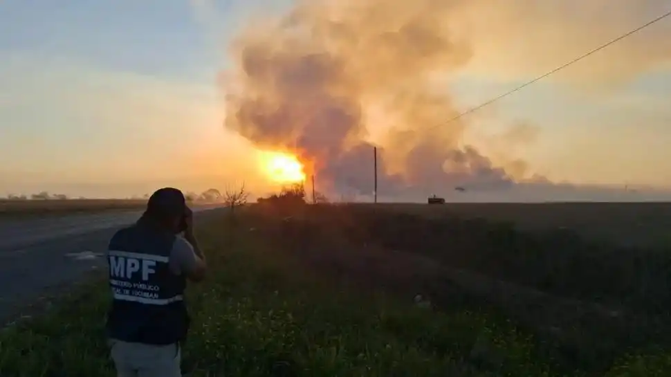 BUSCANDO PRUEBAS. Un perito del ECIF toma imágenes de la columna de humo que generó un incendio cerca de una ruta en el interior tucumano.