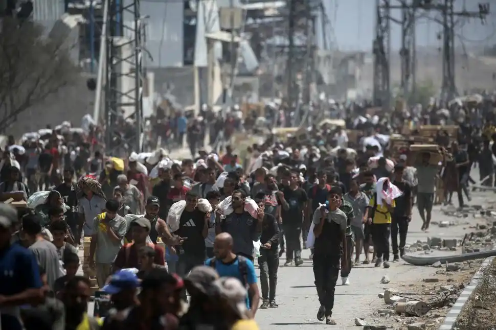 REFUGIADOS. El regreso al campo de Nuseirat, luego de haber esperado horas para conseguir comida.