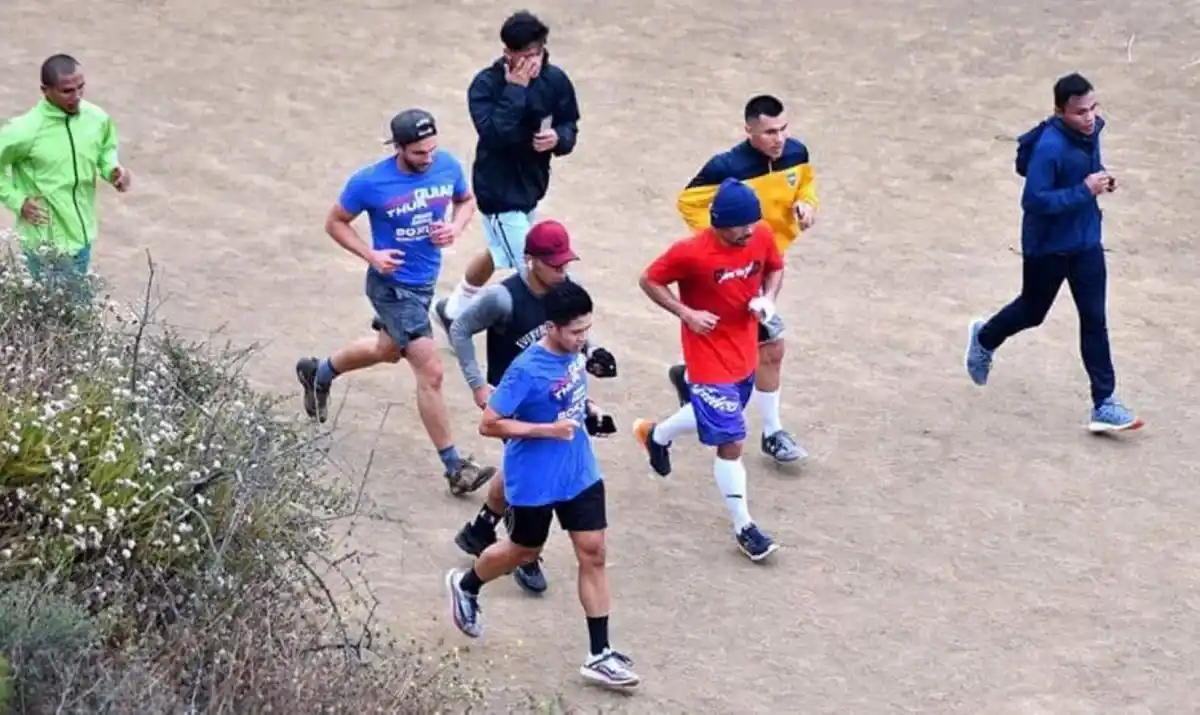 JUNTO AL ÍDOLO. Coria (buzo de Boca) corre con Manny Pacquiao (remera roja), el boxeador al que admiraba desde chico. Fue en Los Ángeles y casi como tocar el cielo con las manos.