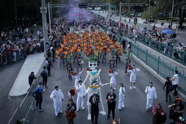 FIESTA POPULAR. Una multitud avanza por las calles, entre música, colores y  enormes figuras tradicionales que aparecen en esta celebración.