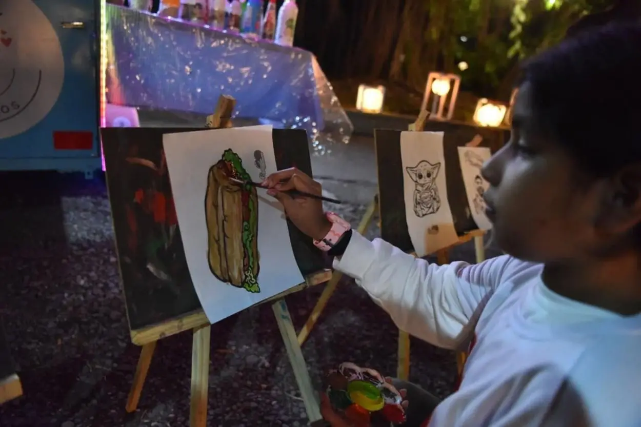 PEQUEÑA ARTISTA. La niña pinta con témperas su sánguche favorito.