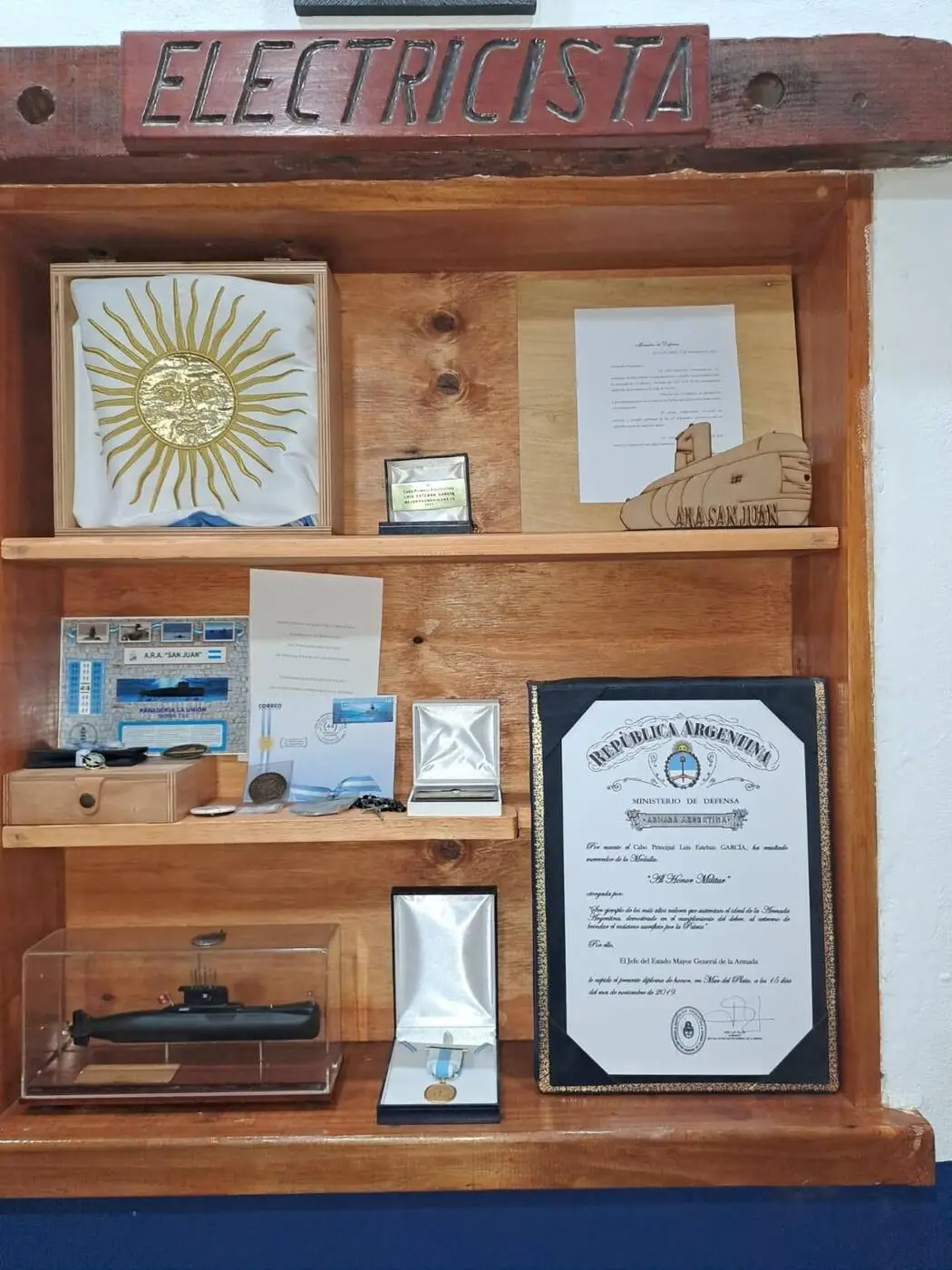 RECUERDOS. Medallas, placas, diplomas y la bandera nacional  evocan al marino tucumano.