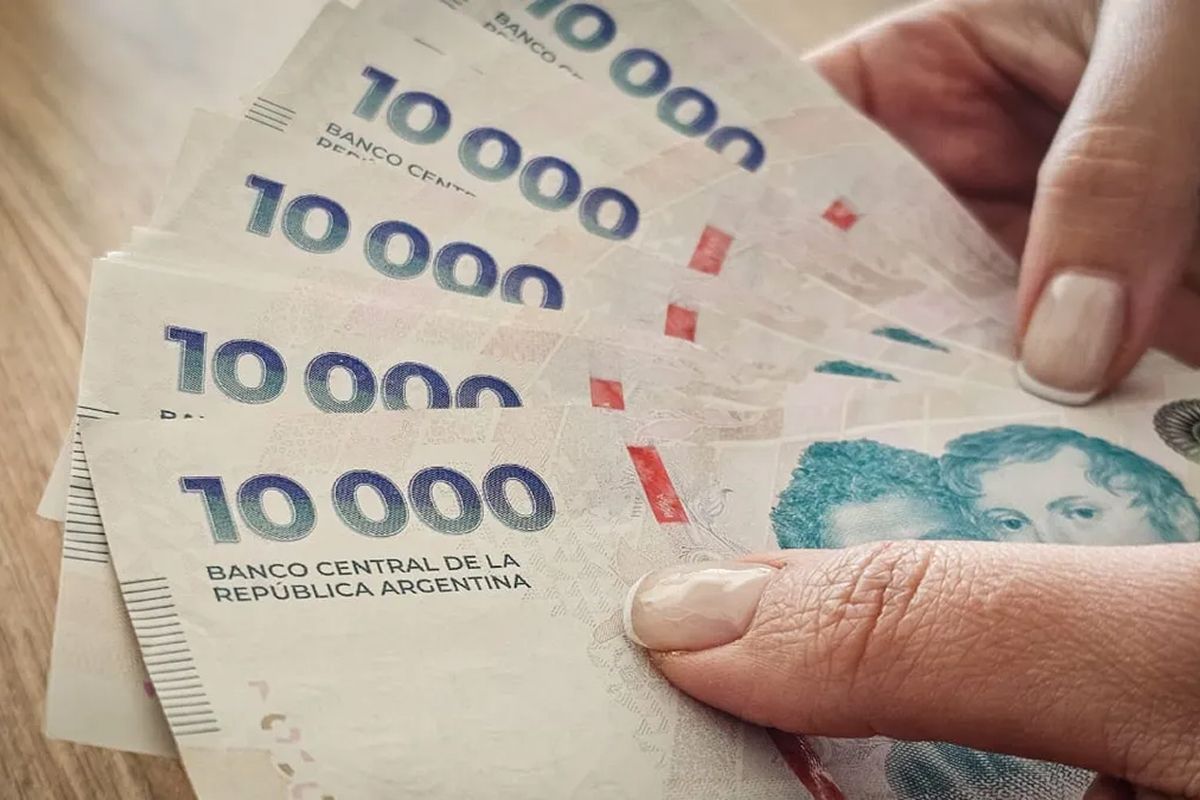 Billetes y calculadora sobre mesa, ilustrando tasas de interés