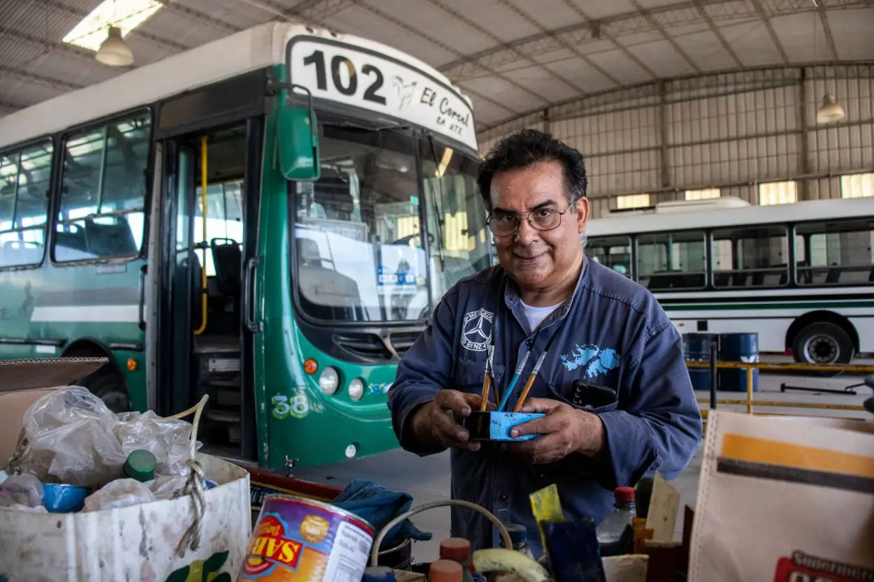 CON SUS HERRAMIENTAS. José Pedro Ríos sostiene los pinceles en el taller donde pinta los colectivos con estilo fileteado.