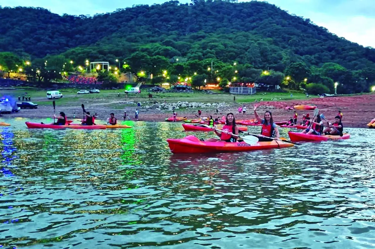 AL COMIENZO. Cuando todavía quedaba algo de sol, los participantes levantan sus manos mientras están subidos en los kayaks. La jornada comenzó oficialmente pasadas las 20.