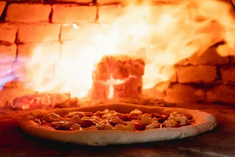 TBC: EN LLAMAS. La masa madre, fermentada durante horas, se infla al contacto con el horno napolitano. La cocción dura apenas un minuto.