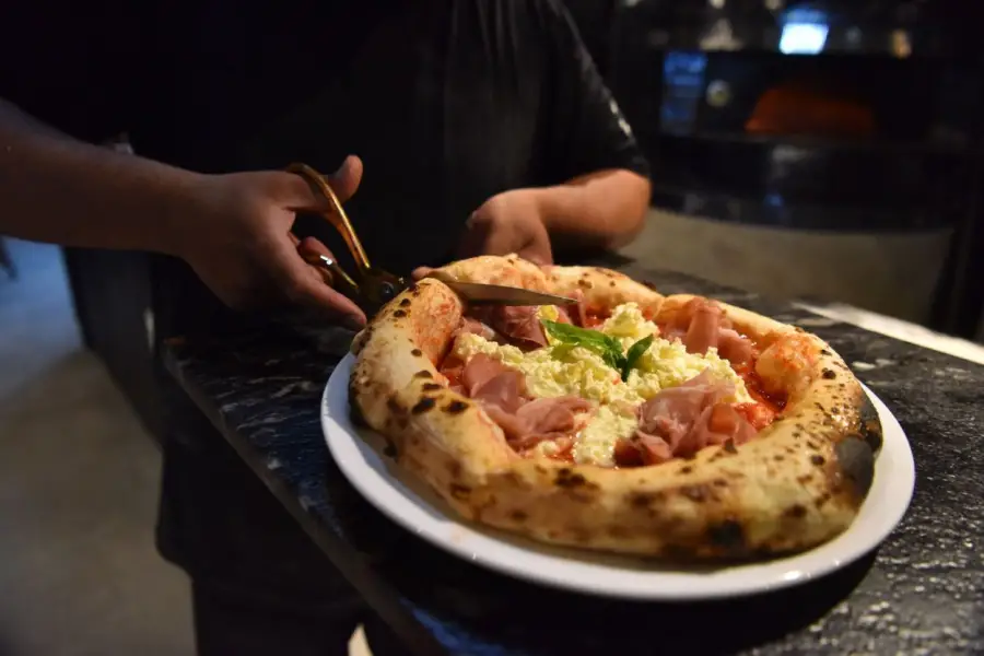 GONNA: UN RITUAL. La famosa napolitana se corta con tijera para cuidar el borde aireado. Se preserva el cornicione y es parte de la experiencia.