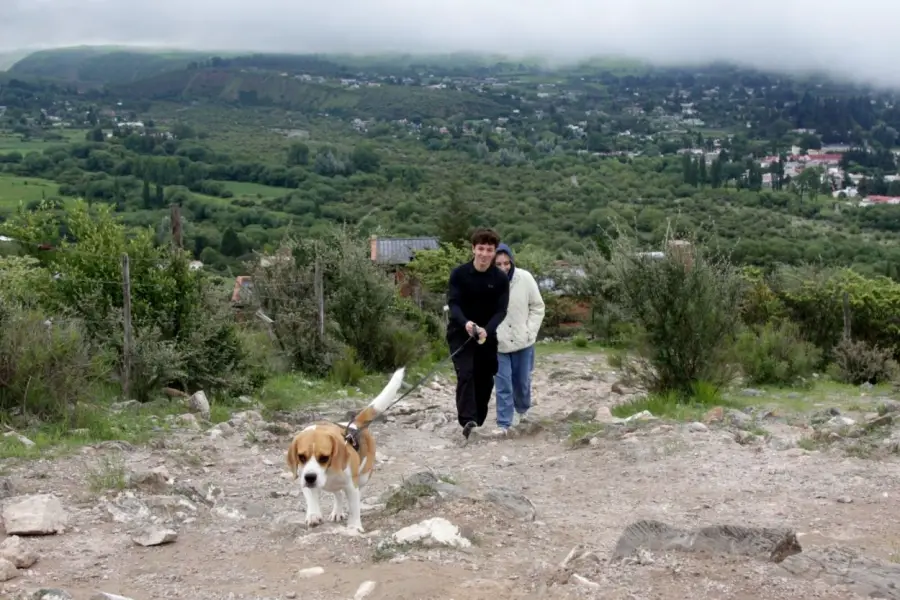 CON LA MASCOTA. Una pareja lleva de paseo al perro por el sendero.