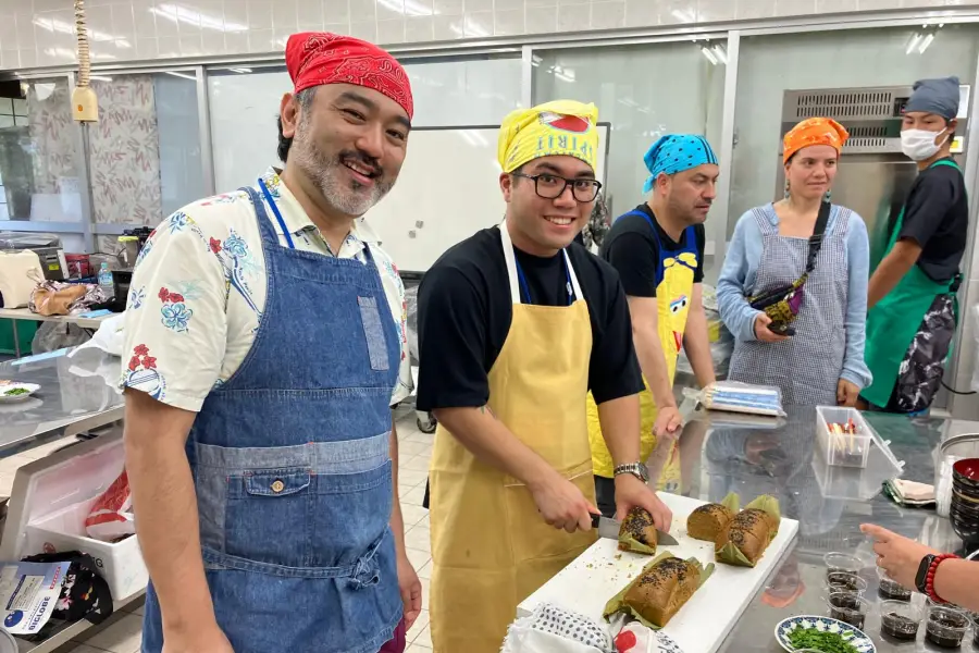Preparación de agarasa, un budín de azúcar morena cocido al vapor durante la clase de cocina okinawense