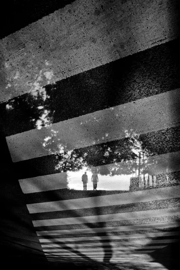 PERSONAS EN TRÁNSITO. Dos siluetas se recortan en un paso peatonal.