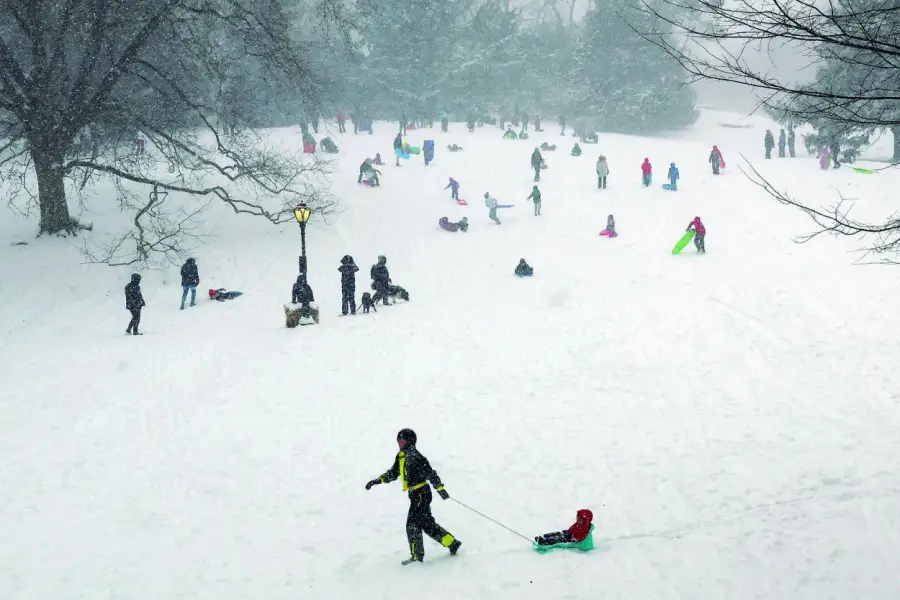 EN EL CENTRAL PARK. Residentes de Nueva York salieron a aprovechar la nieve para andar en trineos. afp