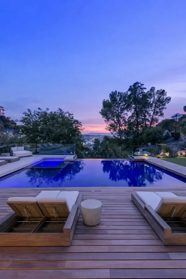 Un oasis difícil de encontrar en Los Ángeles: jardín amplio, palmeras y áreas de descanso rodean la casa.