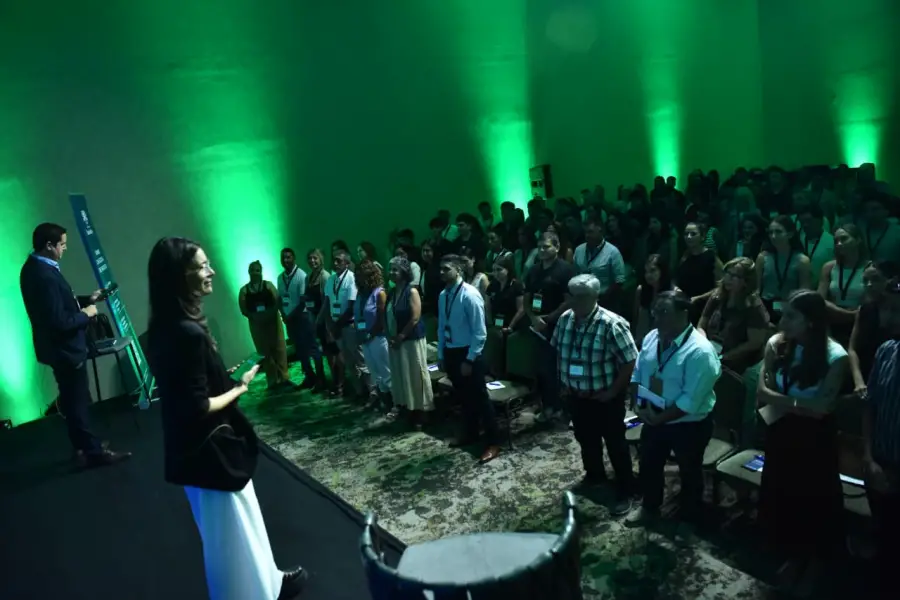 UN MINUTO SIN PANTALLAS. El público de pie, sin celulares ni relojes, durante el ejercicio del “minuto interno” propuesto para reflexionar sobre el tiempo y la atención. / LA GACETA, OSVALDO RIPOLL