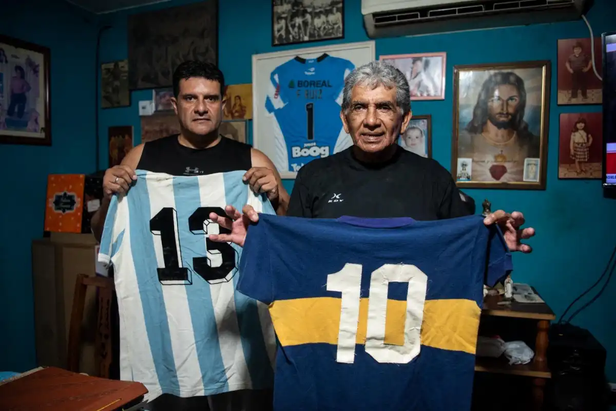 FAMILIA. El ex arquero sostiene una camiseta de Diego Maradona mientras posa junto a Emanuel Ruiz, uno de sus hijos.