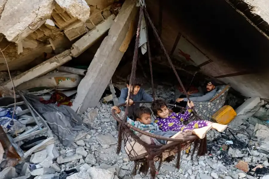 DESPLAZADOS POR LA GUERRA. Jóvenes y niños palestinos en refugios temporales levantados entre los restos de edificios destruidos. / REUTERS.