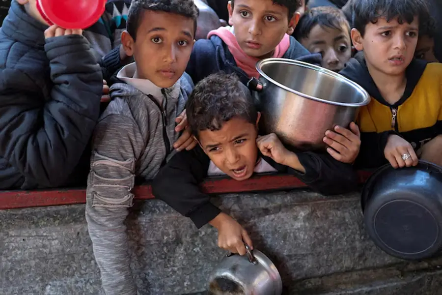 HAMBRE EN GUERRA. Niños palestinos esperan comida en un punto de distribución de ayuda humanitaria en Gaza. / UNICEF