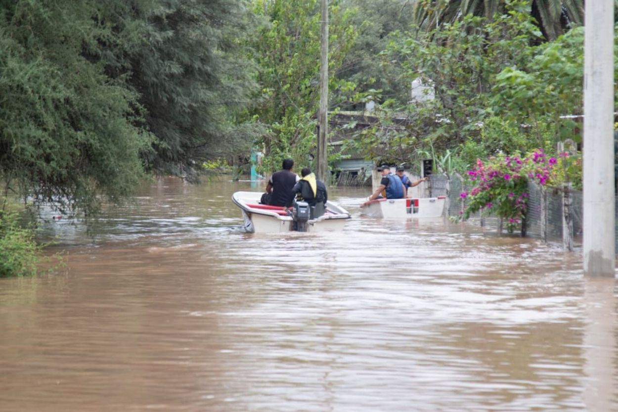 EN LANCHAS. Rescatistas recorren La Madrid para evacuar a vecinos.