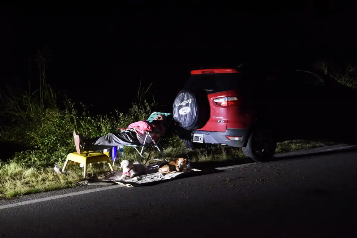 RINCÓN. Las luces de un auto iluminan a los dos perros de una familia junto a sus pertenencias y su auto en plena ruta 157. LA GACETA / FOTO DE DIEGO ARÁOZ
