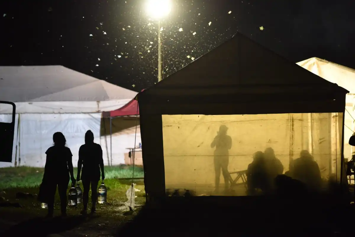SOMBRAS. Antes de irse a dormir, varias mujeres fuman y conversan dentro de su carpa. LA GACETA / FOTO DE DEGO ARÁOZ