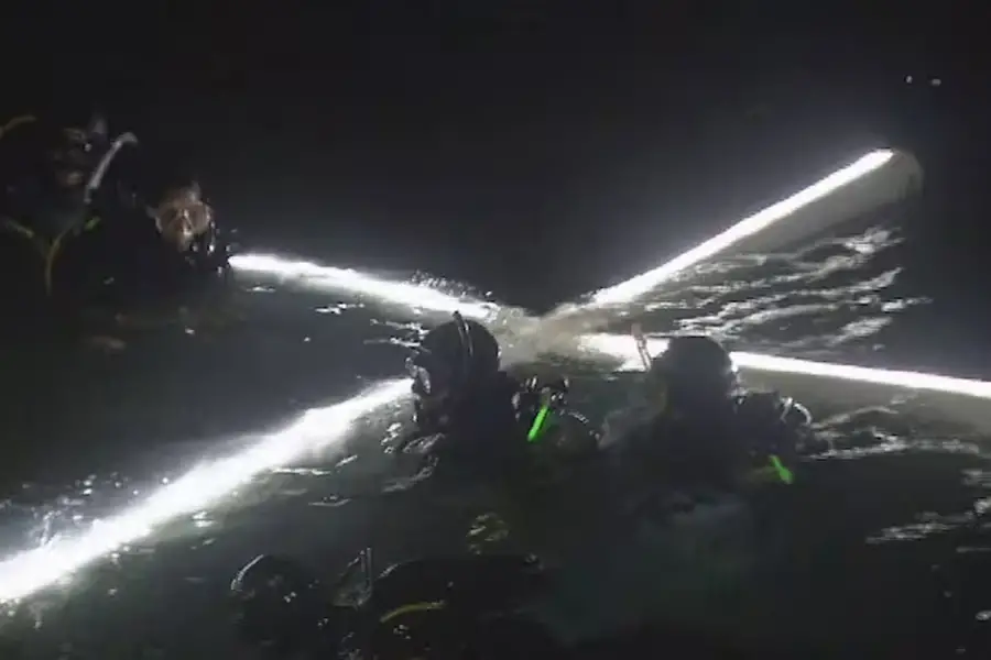 La cruz iluminada desciende en el mar del Golfo Nuevo. 