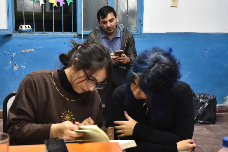 SOLANGE Y MARTINA, CON ARMANDO DETRÁS. Comparten la lectura de sus textos en el taller de escritura de La Escuelita de Famaillá. / LA GACETA, OSVALDO RIPOLL