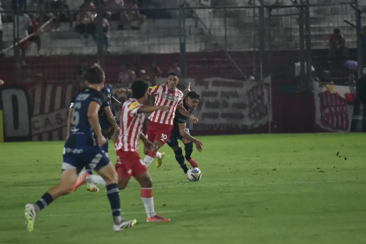 INTENTO. Nicolás Castro busca filtrar un pase para Alan Cisnero ante la marca del rival.