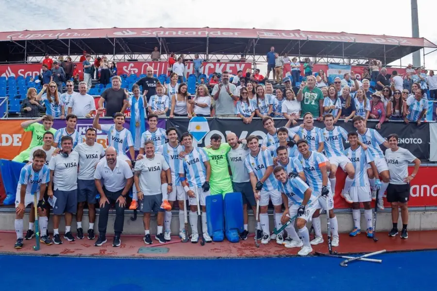 UNIÓN. El plantel argentino posa junto al cuerpo técnico y familiares tras la consagración, con medallas, banderas y la alegría desatada en la tribuna.