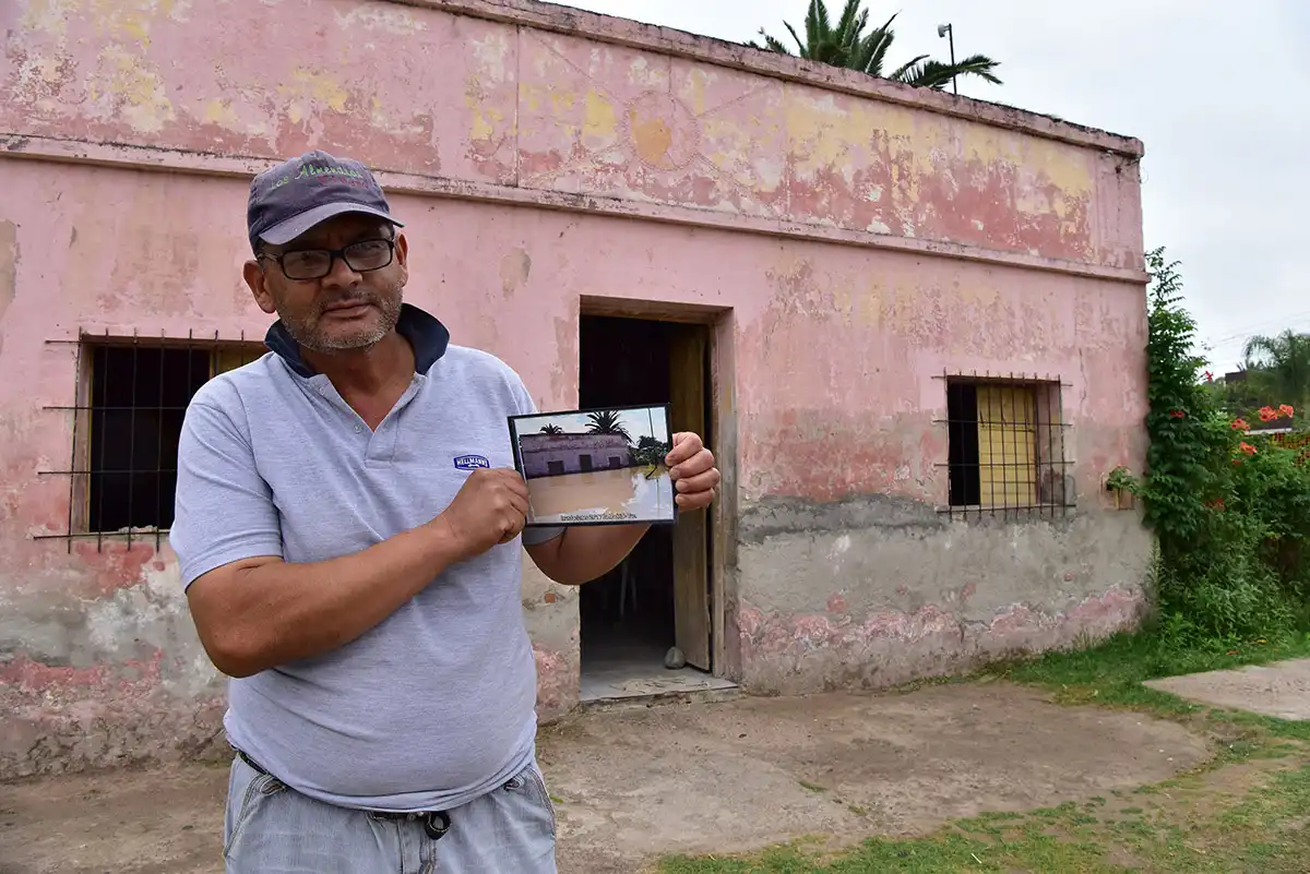 UN RECUERDO: El reportero gráfico Osvaldo Ripoll retrató a Carlos Palomino en el año 2017. En esta imagen sostiene una foto de su casa inundada tomada por Juan Salazar. FOTO: DIEGO ARÁOZ