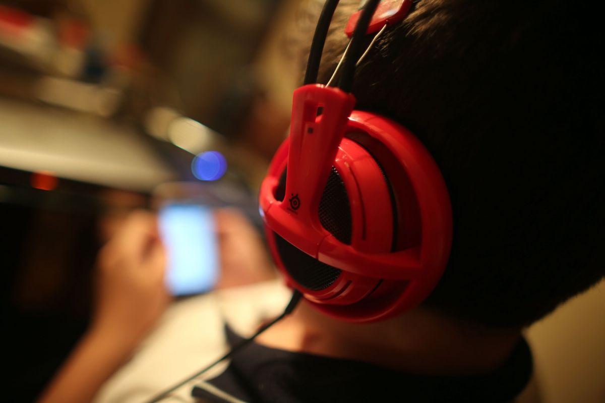 PANTALLAS. Un niño mira el teléfono y usa auriculares. Preocupa la dependencia a los estímulos que generan las redes en los chicos.