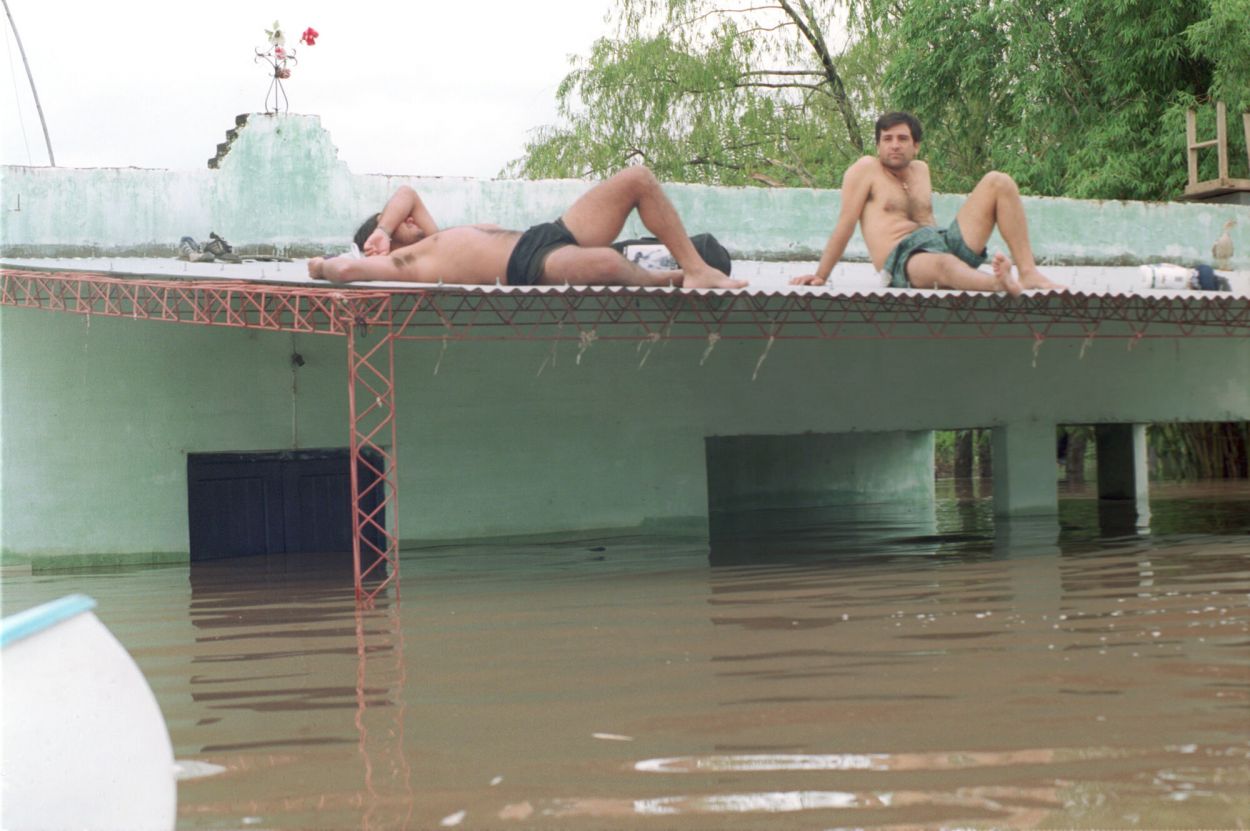 REFUGIO. Pobladores en los techos de sus casas -archivo año 2000-.