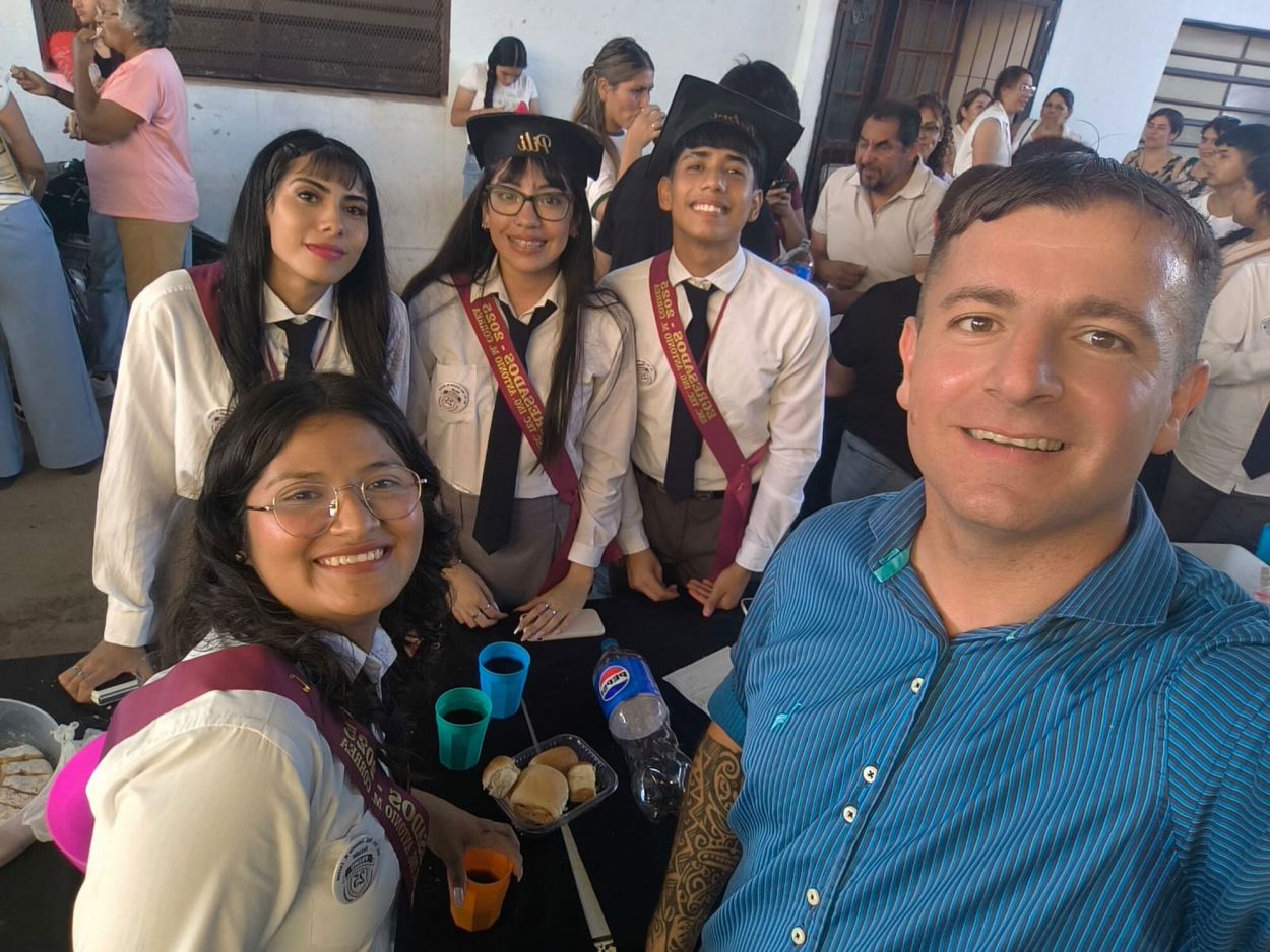 ORGULLOSO. El docente junto a algunas alumnas de su escuela técnica.