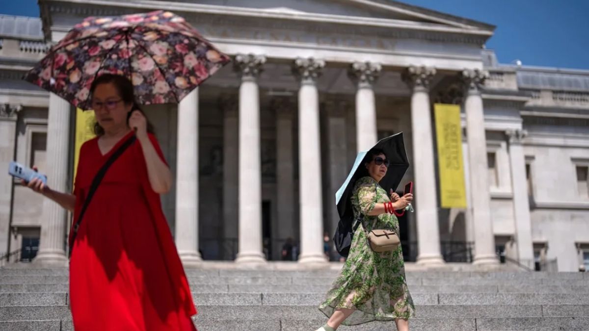 Las mujeres se resguardan del sol bajo paraguas mientras visitan Trafalgar Square, Londres, el martes 23 de junio de 2026. Carl Court/Getty Images/CNN