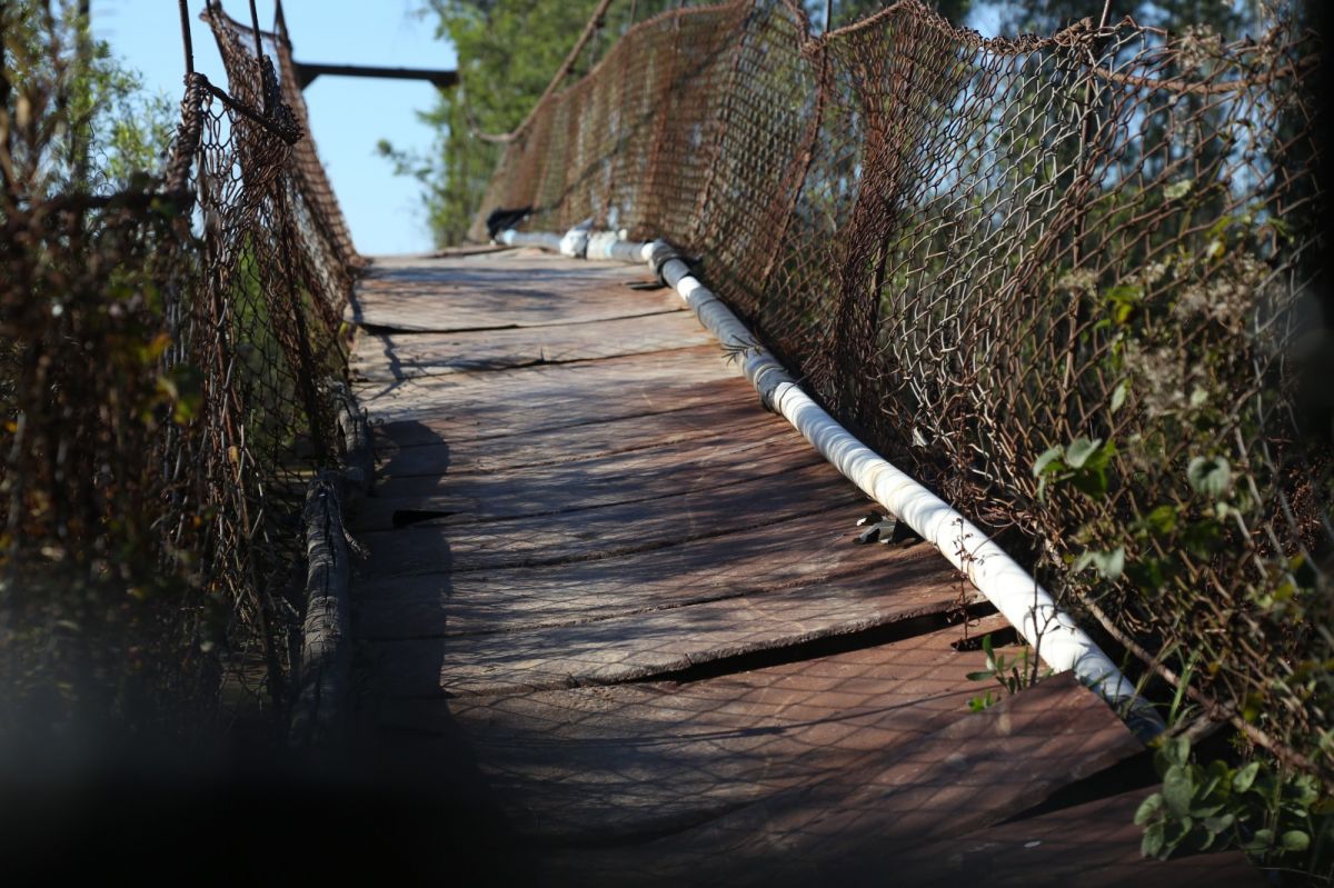 FRAGILIDAD. El puente colgante que une Los Jereces con Sol de Mayo continúa siendo el principal paso entre ambos parajes. Las antiguas tablas de madera fueron reemplazadas por chapas, pero la estructura permanece deteriorada y se mueve con cada cruce.