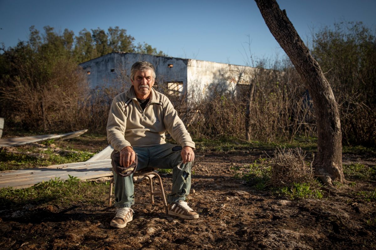 MEMORIA. Francisco Jerez posa frente a la antigua Escuela N° 151 de Sol de Mayo, donde cursó sus primeros años. El edificio dejó de funcionar en 2024 y hoy permanece abandonado, convertido en uno de los símbolos del impacto que las inundaciones tuvieron sobre la zona.