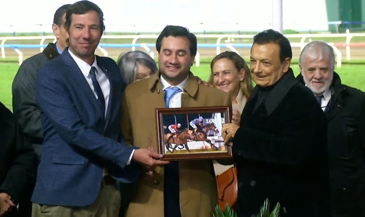 PREMIACIÓN. Facundo Levi (centro) y José Sarquiz (derecha) celebraron la gran victoria del zaino nacido en el haras Orilla del Monte.