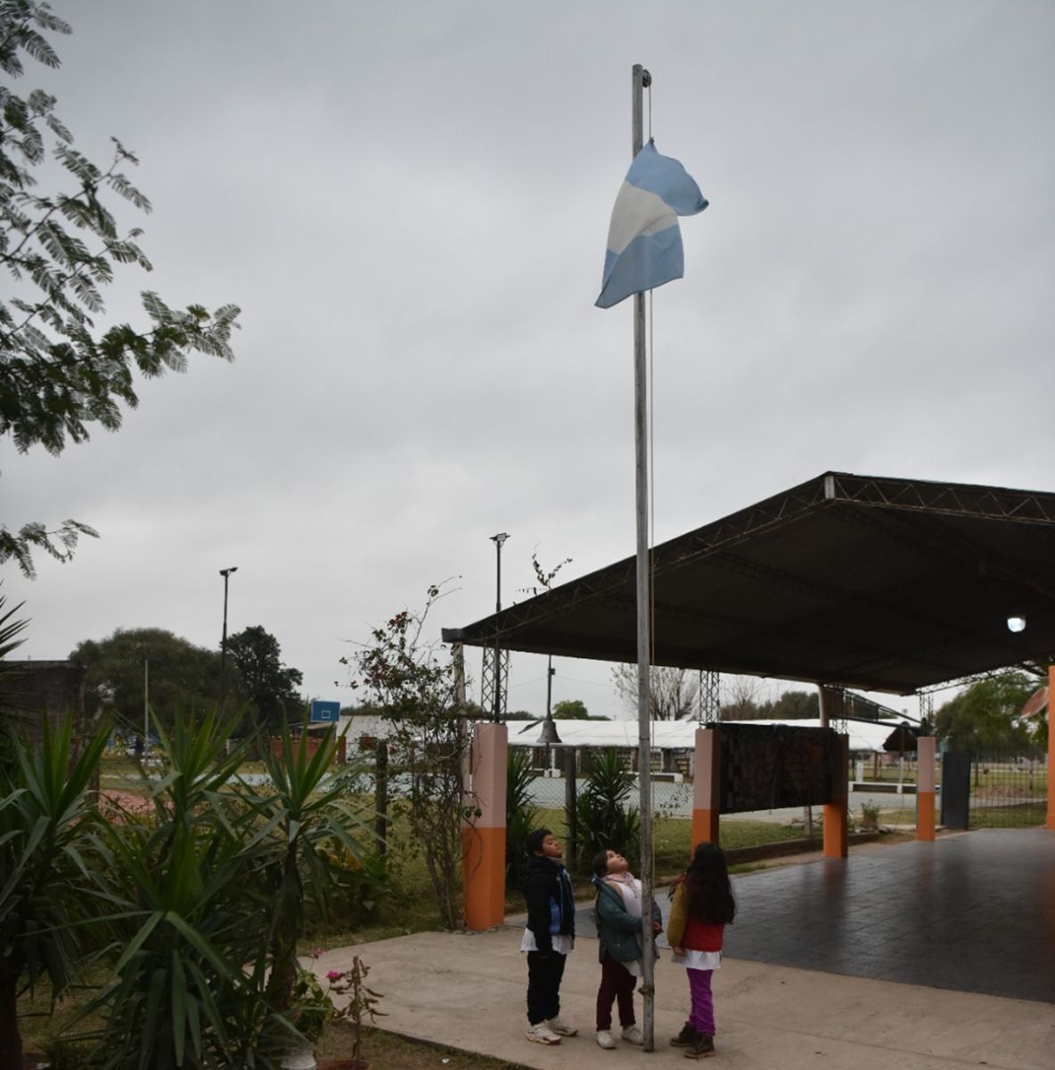 LA BANDERA. Antes de entrar a clases, alumnos de la Escuela N.° 57 observan la bandera argentina. En 7 de Abril, el Mundial también se vive puertas adentro de la escuela. / LA GACETA, GALLE QUINTANA