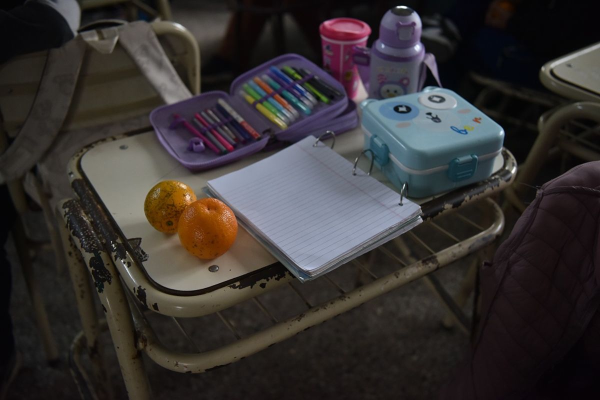 RECREO. Un pupitre con útiles, mandarinas y la vianda de un alumno durante la jornada escolar. / LA GACETA, GALLE QUINTANA
