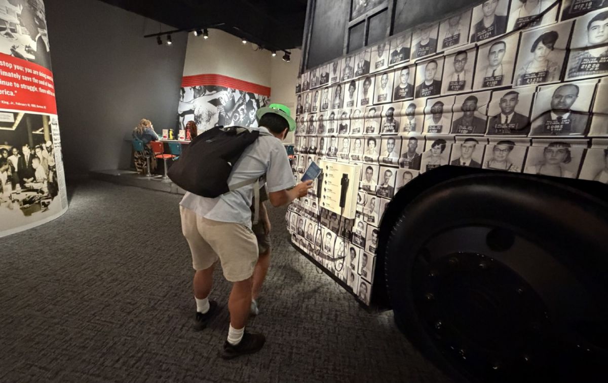 SORPRENDIDOS. Jay y su hijo observan un ómnibus cubierto con fotografías de personas detenidas durante las protestas contra la segregación racial.