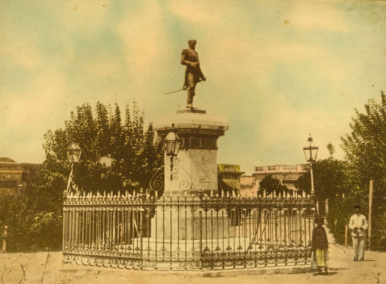 ESTATUA IMPORTANTE. El monumento al héroe de la Independencia argentina, tal como existía en el centro de la plaza Independencia desde 1883. En 1904 fue trasladada a la plaza Belgrano.