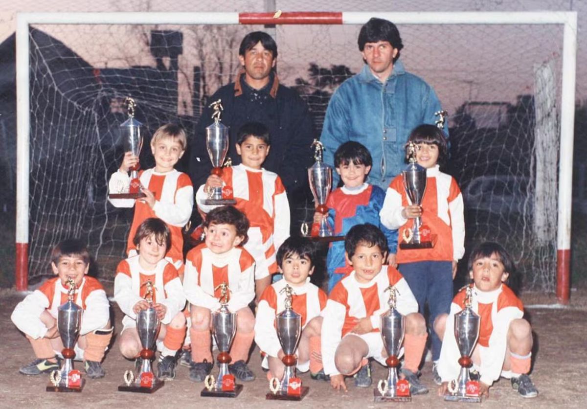Jorge, parado con campera azul, posa con el equipo de Lionel. 