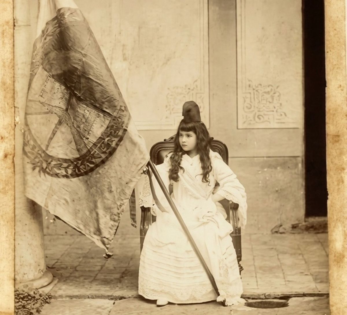 A PRINCIPIOS DEL SIGLO XX. La foto muestra a la niña jujeña María Catalina Wiaggio mientras posa con la histórica bandera nacional de la Libertad Civil (la imagen fue mejorada con IA).
